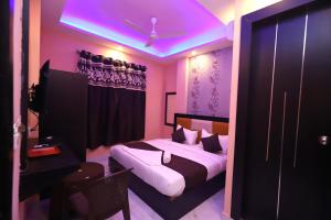 ニューデリーにあるJupiter Gold Delhi Airportの紫色の天井のベッドルーム1室