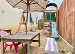 a wooden table and chairs with an umbrella and a slide at National City Gem 3 BD 2 5 BTH in National City