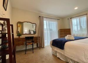 a bedroom with a bed and a desk and a mirror at National City Gem 3 BD 2 5 BTH in National City