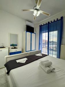 a bedroom with a large bed with towels on it at Hotel Elena in Pyrgadikia