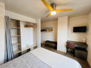 a bedroom with a bed and a ceiling fan at L'Océane Bed&Breakfast in Lacanau-Océan