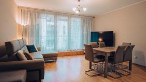 a living room with a table and chairs and a couch at Apartament Stylowy - Zeta Park in Ustroń