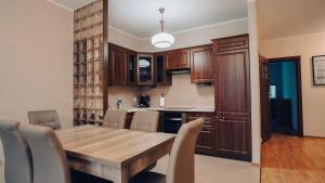 eine Küche mit einem Holztisch und Stühlen in der Unterkunft Apartament Stylowy - Zeta Park in Ustroń