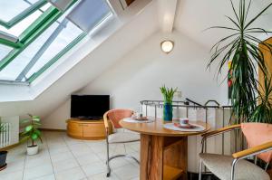 Una sala de estar con una mesa y sillas y un televisor. en Bodenseeblick, en Meersburg