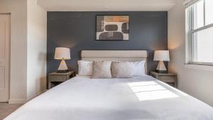 um quarto com uma grande cama branca e 2 candeeiros em Landing Modern Apartment with Amazing Amenities (ID8083X42) em Fort Myers Villas