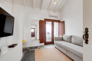 een woonkamer met een bank en een tv bij Casa da Junqueira - Lago do Alqueva in Campinho