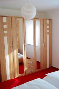 1 dormitorio con armarios de madera y espejo grande en Ferienwohnung Kottmarsdorf, en Kottmarsdorf