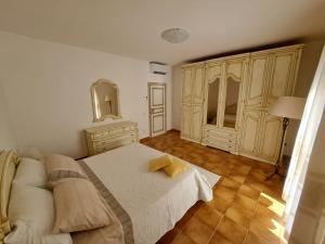 a bedroom with a bed and a dresser and a mirror at Gli Olivastri Guest House in Arzachena
