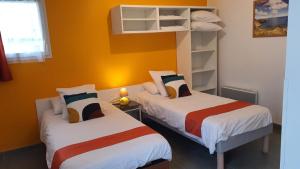 two beds in a room with yellow walls at La Vigie Vacances in Les Sables-dʼOlonne