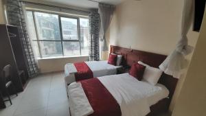 Postel nebo postele na pokoji v ubytování Epitome Times Hotel