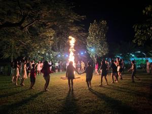 a group of people standing in a park with a fire at KHÁCH SẠN AQUARIUSGARDEN VÂN LONG NINH BÌNH in Ninh Binh