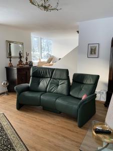 a green leather couch in a living room at Nefer, Haus in Bad Gastein