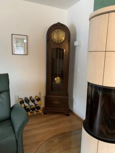 una sala de estar con un reloj de abuelo y un sofá en Nefer, Haus en Bad Gastein