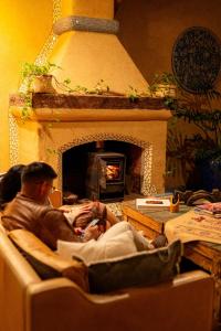 un hombre y una mujer sentados en una sala de estar con chimenea en EQUIMITE CASA DE CAMPO, en Coatepec