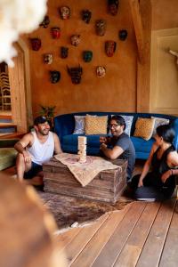 tres hombres sentados en una sala de estar con un sofá azul en EQUIMITE CASA DE CAMPO, en Coatepec