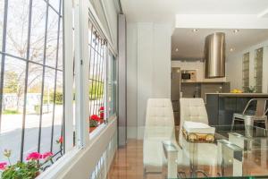 jadalnia i kuchnia ze szklanym stołem i krzesłami w obiekcie Bright Apartment Torrevieja + Pool w mieście Torrevieja