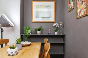 un comedor con una mesa de madera y plantas en 1-Bed Apartment in Bethnal Green, en Londres