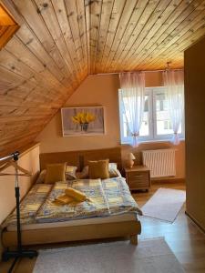 a bedroom with a large bed with a wooden ceiling at Apartmánový dom Anna in Stará Lesná