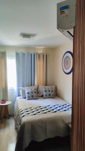 um quarto com uma cama com almofadas em Flat Lindíssimo Beira-Mar em Salvador