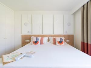 Un dormitorio con una gran cama blanca con unas tijeras. en HD Parque Cristobal Gran Canaria, en Playa del Inglés