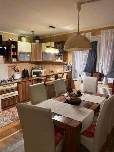 eine Küche mit einem Holztisch und Stühlen sowie ein Esszimmer in der Unterkunft Apartmánový dom Anna in Stará Lesná