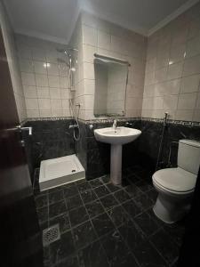 uma casa de banho com um WC, um lavatório e um chuveiro em فندق إي دبليو جي النزهة متوفر توصيل مجاني للحرم em Meca