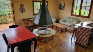 a living room with a table and a fireplace at CASA EM MONTE VERDE-MG ACOMODA 15 PESSOAS in Monte Verde