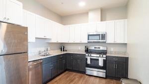 une cuisine avec des armoires noires et des appareils blancs dans l'établissement Landing Modern Apartment with Amazing Amenities (ID6080X83), à Salem