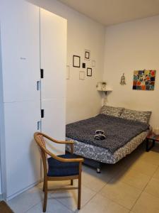 1 dormitorio con 1 cama y 1 silla en Cute Studio near Yad Vashem FREE street parking en Jerusalén