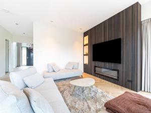 ein Wohnzimmer mit einer weißen Couch und einem Kamin in der Unterkunft Beautiful water villa near Harderwijk in Zeewolde