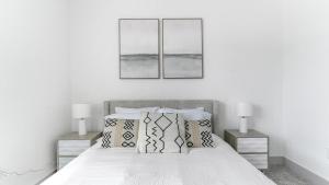 een slaapkamer met een bed met twee foto's aan de muur bij Landing - Modern Apartment with Amazing Amenities (ID1398X195) in Richmond