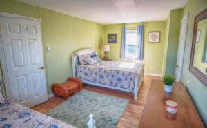 a bedroom with a bed and a chair and a table at Gorgeous beach house with large pool & private beach, just 3 blocks away!! in Point Pleasant Beach