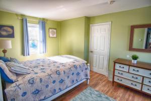 a bedroom with a bed and a dresser and a window at Gorgeous beach house with large pool & private beach, just 3 blocks away!! in Point Pleasant Beach