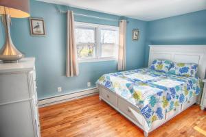 Dormitorio azul con cama y ventana en Gorgeous beach house with large pool & private beach, just 3 blocks away!!, en Point Pleasant Beach