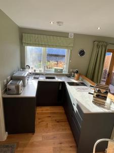 a kitchen with a sink and a counter top at The Poplars - Cosy Modern Flat with Great Networking in Telford