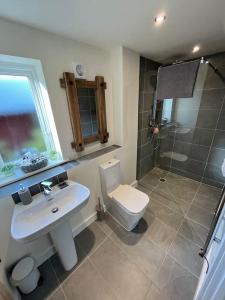 a bathroom with a sink and a toilet and a shower at The Poplars - Cosy Modern Flat with Great Networking in Telford
