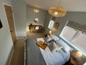 a bedroom with a bed with pillows and a table at The Poplars - Cosy Modern Flat with Great Networking in Telford