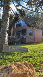 uma casa com um sinal em frente a uma árvore em Cabana 16 em São Francisco de Paula