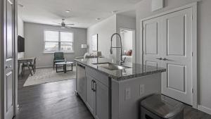 a kitchen with a sink and a living room at Landing - Modern Apartment with Amazing Amenities (ID1403X426) in Houston