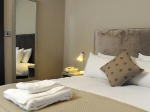 1 dormitorio con 1 cama con toallas en The Red Lion Hotel, en Cambridge