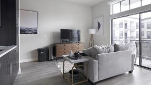 un soggiorno con divano e TV di Landing - Modern Apartment with Amazing Amenities (ID1403X354) a Houston