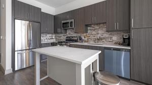 a kitchen with wooden cabinets and a white counter top at Landing - Modern Apartment with Amazing Amenities (ID1403X401) in Houston