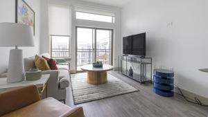 a living room with a couch and a tv at Landing - Modern Apartment with Amazing Amenities (ID1403X401) in Houston