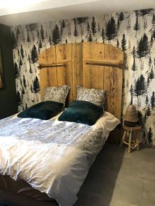 a bedroom with a large bed with a wooden headboard at Le cocon du rondeau(gîte cosy) in Labergement-Sainte-Marie