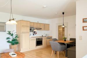 a kitchen and living room with a table and chairs at Haffblick Wohnung 65 in Boltenhagen
