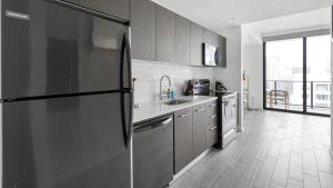 a kitchen with a refrigerator and a sink at Landing - Modern Apartment with Amazing Amenities (ID1401X727) in Fort Lauderdale