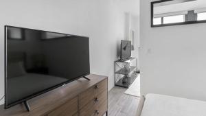 羅德岱堡的住宿－Landing - Modern Apartment with Amazing Amenities (ID1401X725)，客厅配有大屏幕平面电视的梳妆台