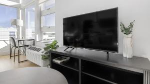 uma sala de estar com uma grande televisão de ecrã plano em Landing - Modern Apartment with Amazing Amenities (ID1401X734) em Denver