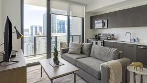 een woonkamer met een bank en een keuken bij Landing - Modern Apartment with Amazing Amenities (ID1401X726) in Fort Lauderdale