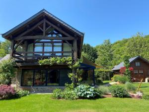 una casa con plantas en la parte delantera en Chambre d'hôtes - Le Refuge de la Vallée, en Érezée